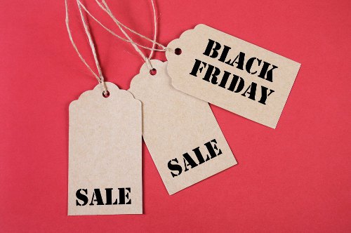 Black Friday Sale message sign on brown paper sale tags on red background.